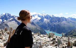 una mujer parada en la cima de una montaña mirando las montañas en Hotel & Suites Glück Auf, en Mayrhofen