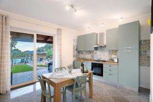 una cucina con tavolo e sedie e una sala da pranzo di Agriresidence Le Grazie a Montecorice