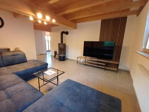 ein Wohnzimmer mit Couch und Flachbildfernseher in der Unterkunft Ferienwohnung Beim Schorsch in Schannenbach