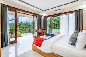 une chambre avec un grand lit et un balcon dans l'établissement Bhargava Prana, à Gianyar