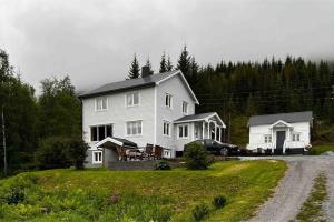 a large white house with a car parked in front of it at Apartment Senja in Senja