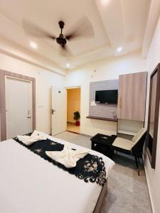 um quarto com uma cama, uma escrivaninha e uma TV em Rudra Ganga Atithi Hotel em Varanasi