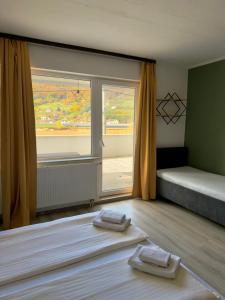 Dobrinjeにある3D Caffe Apartmaniのベッドが2つと大きな窓がある部屋