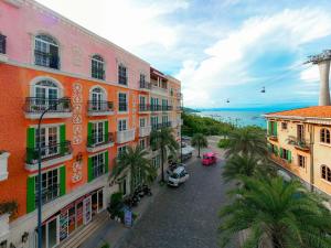 a street with buildings and palm trees and the ocean at Hồng Chúc Hotel in Phu Quoc