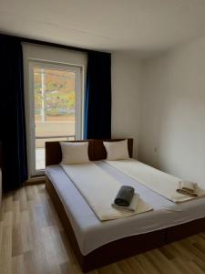 Dobrinjeにある3D Caffe Apartmaniの窓のある大きなベッドのある寝室