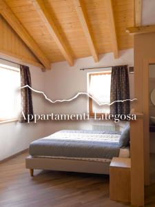 a bedroom with a bed and two windows at Appartamenti LITEGOSA casa vacanza 3 in Panchia