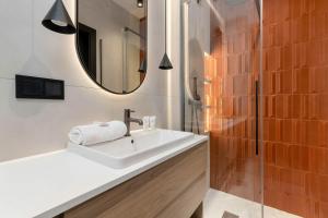 een badkamer met een witte wastafel en een spiegel bij Elegant Studio with Air Conditioning Pet Friendly by Noclegi Renters in Suchanino