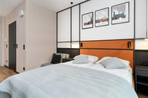 een slaapkamer met een groot wit bed met twee kussens bij Elegant Studio with Air Conditioning Pet Friendly by Noclegi Renters in Suchanino