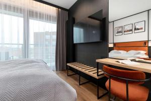 een slaapkamer met een bed, een tafel en een bureau bij Elegant Studio with Air Conditioning Pet Friendly by Noclegi Renters in Suchanino +9 foto's