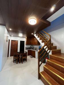 ein Raum mit Treppe und eine Küche mit Tisch in der Unterkunft BALAI MALINAWON - Villa 2 in General Luna