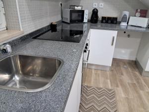 a kitchen with a sink and a microwave at Casa do Sardão in Sardoal +24 photos
