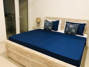 a bed with blue sheets and pillows in a room at Fairway Galle in Galle