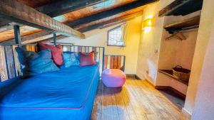 a blue bed with colorful pillows in a room at Borgo Felice Fontana - Affitti Brevi Italia in Monfol