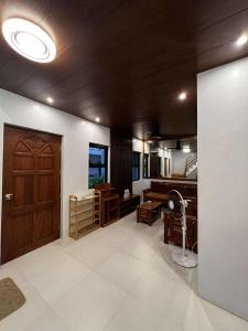 ein Wohnzimmer mit Holztür und Ventilator in der Unterkunft BALAI MALINAWON - Villa 2 in General Luna