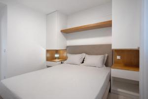 Un dormitorio con una gran cama blanca. en T3 São Martinho do Porto, en São Martinho do Porto