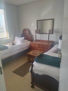 een slaapkamer met 2 bedden en een dressoir met een spiegel bij On the Beach 20 in Swakopmund