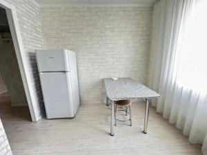Cette chambre comprend une petite table et un réfrigérateur. dans l'établissement New! 2-комнатная квартира В САМОМ ЦЕНТРЕ ГОРОДА, à Petropavlovsk-Kamtchatski