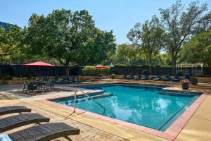 a swimming pool with chairs and a table at Renaissance Dallas Addison in Addison