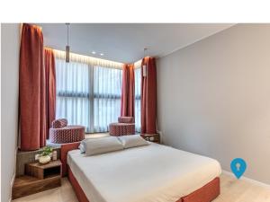 a bedroom with a bed and a window with red curtains at Triplyrooms Collection - Parioli in Rome
