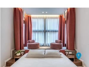 a bedroom with a bed and two chairs in front of a window at TriplyRooms Collection - Parioli in Rome