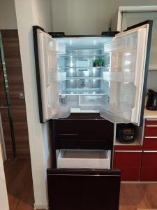 an empty refrigerator with its door open in a kitchen at 一棟貸民泊西戸崎駅前 in Fukuoka