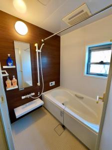 a bathroom with a bath tub and a sink at 一棟貸民泊西戸崎駅前 in Fukuoka
