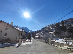 a sun shining over a street with a mountain at Repos et nature au cœur des Alpes in Briançon