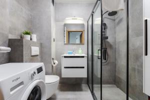 een badkamer met een douche, een toilet en een wastafel bij Nasypowa Spacious Apartment by BookingHost in Gdynia +25 foto's
