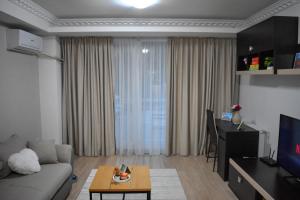 een woonkamer met een bank en een tafel bij WRW Airport Residence in Otopeni