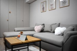 een woonkamer met een bank en een salontafel bij WRW Airport Residence in Otopeni