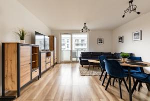 een woonkamer met een tafel en een bank bij Nasypowa Spacious Apartment by BookingHost in Gdynia