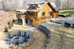 a large log cabin with chairs and a fire pit at Karaoke Hot Tub 1GB WiFi - The Rock House - LUX in Rogers