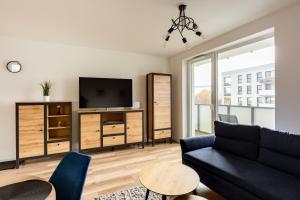 een woonkamer met een bank en een tv bij Nasypowa Spacious Apartment by BookingHost in Gdynia