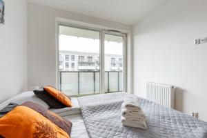 een slaapkamer met een bed en een groot raam bij Nasypowa Spacious Apartment by BookingHost in Gdynia