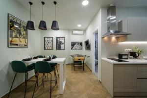 a kitchen with a white table and green chairs at 2 BR Apartment with Sitcom Vibes VIPGreece in Athens +26 photos