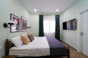 a bedroom with a bed and a tv on the wall at 2 BR Apartment with Sitcom Vibes VIPGreece in Athens
