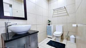 a bathroom with a sink and a toilet at Nautica 009 Studio Flat in Mossel Bay +22 photos