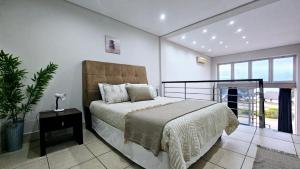 a bedroom with a bed and a large window at Nautica 009 Studio Flat in Mossel Bay