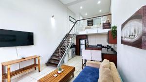a living room with a couch and a staircase at Nautica 009 Studio Flat in Mossel Bay