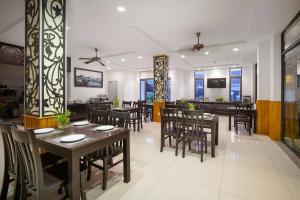une salle à manger avec des tables et des chaises dans un restaurant dans l'établissement Hoi An Beachfront Hotel, à Tân Thành (1)