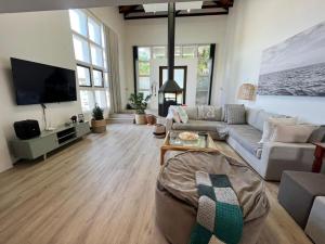 a living room with a couch and a tv at SeaSalt Escape in Plettenberg Bay