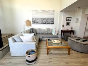 a living room with a couch and a coffee table at SeaSalt Escape in Plettenberg Bay +37 photos