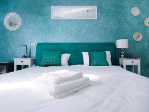a bedroom with a white bed with blue walls at Popasul Castelului in Hunedoara