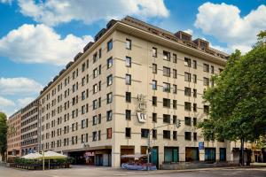 a large white building on a city street at Aloft München in Munich