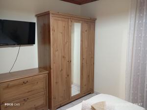 a wooden cabinet with a television on top of it at Villa Karanti in Limenas