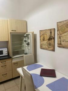 een keuken met een tafel met stoelen en een magnetron bij Electra apartment in Thiva