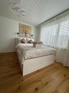 a bedroom with a large bed in a white room at Gästehaus MaryVitty, zentrale zwischen Aarau und Olten, gut verbunden in Schönenwerd