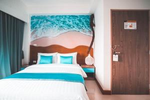 een slaapkamer met een bed met een schilderij aan de muur bij Jomtien Beach Market Place in Jomtien Beach