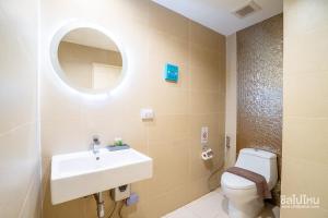 een badkamer met een wastafel, een toilet en een spiegel bij Jomtien Beach Market Place in Jomtien Beach +26 foto's