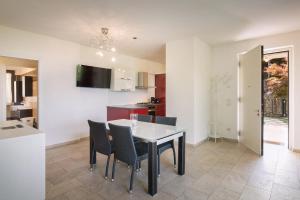 トッリ・デル・ベーナコにあるVilla Loncrino - Fine Livingのテーブルと椅子のあるキッチンとダイニングルーム